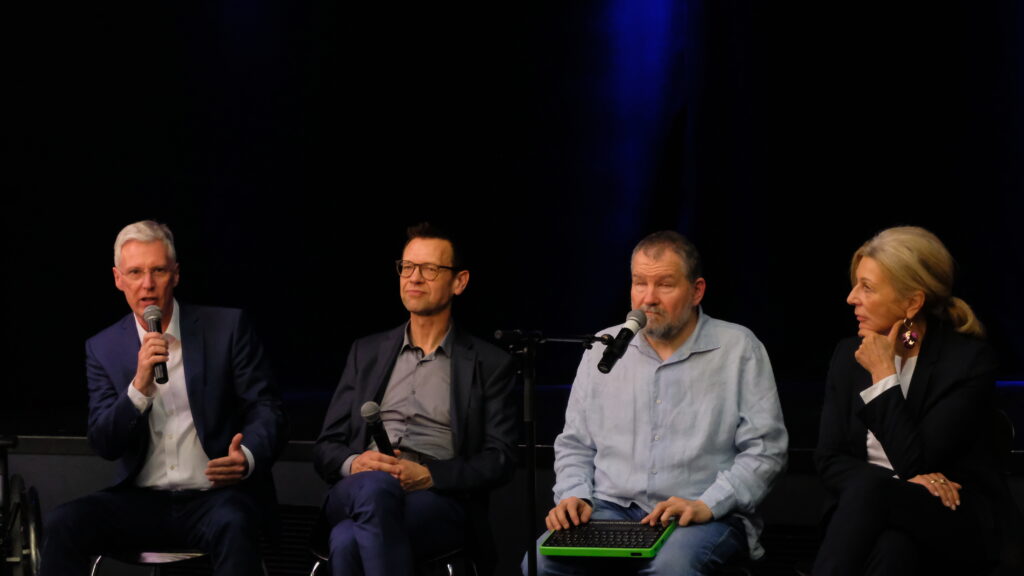 Ingo Schleuse spricht ins Mikrofon, neben ihm sitzen Peter Gorzkulla-Lüdemann, Sascha Lang und Michaela Pries.