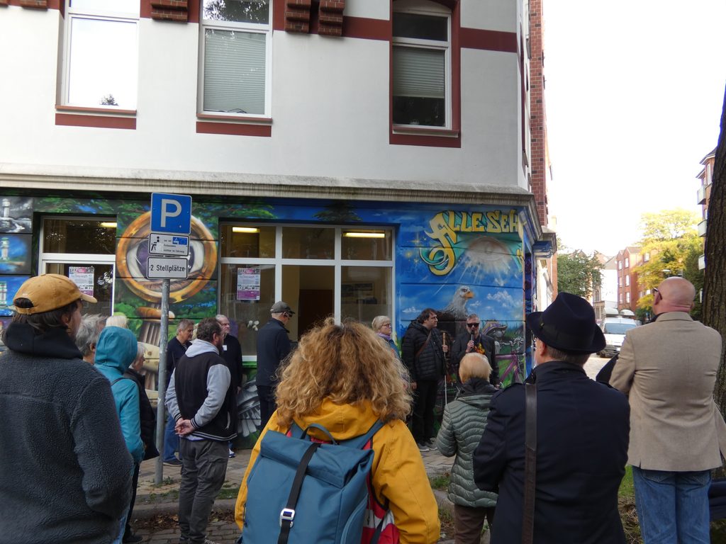 BSVSH Vorsitzender Jürgen Trinkus und Petra Drodofsky und Niels Luithart von der Regionalgruppe Kiel begrüßen das Publikum vor der neu gestalteten Fassade der Begegnungsstätte